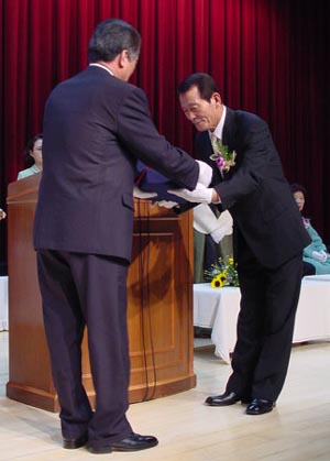여수대학교 이삼노 총장으로 부터 교직원이 수여하는 감사패를 받고 있는 신석우 교수