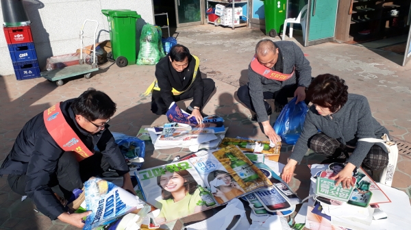 지난 21일 여수시 공무원과 위생단체협의회원으로 구성된 환경파수꾼들이 음식업소의 주류 광고물을 철거한 후 정리 작업을 하고 있다.