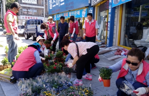 문수동 주민자치위원들이 상가 꽃길 조성사업을 하고 있다.