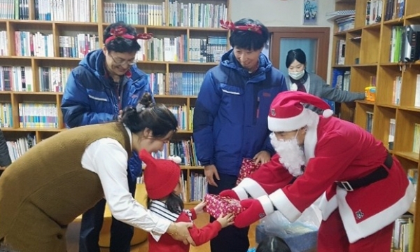 금호석유화학 봉사단이 산타로 분장해 여수지역 아동센터 아이들에게 크리스마스 선물을 전달하고 있다.