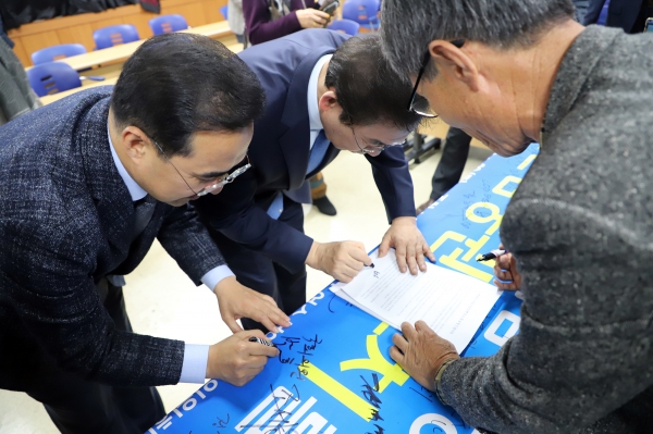 박원순 서울시장과 박홍근 의원이 당사국총회 유치를 지지하는 내용의 사인을 하고 있다.