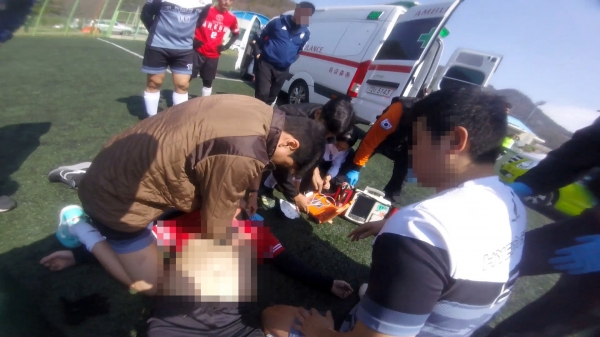 18일 진남경기장에서 열린 축구대회 도중 참가 선수가 갑자기 쓰러져 소방관들이 응급처치를 하고 있다.