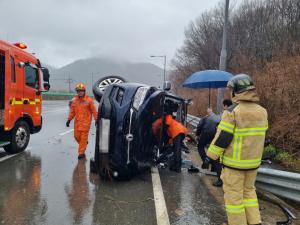 28일 화양면의 한 도로에서 차량이 빗길에 넘어지는 사고가 발생해 119구조대에 의해 구조되고 있다. (사진=여수소방서 제공)